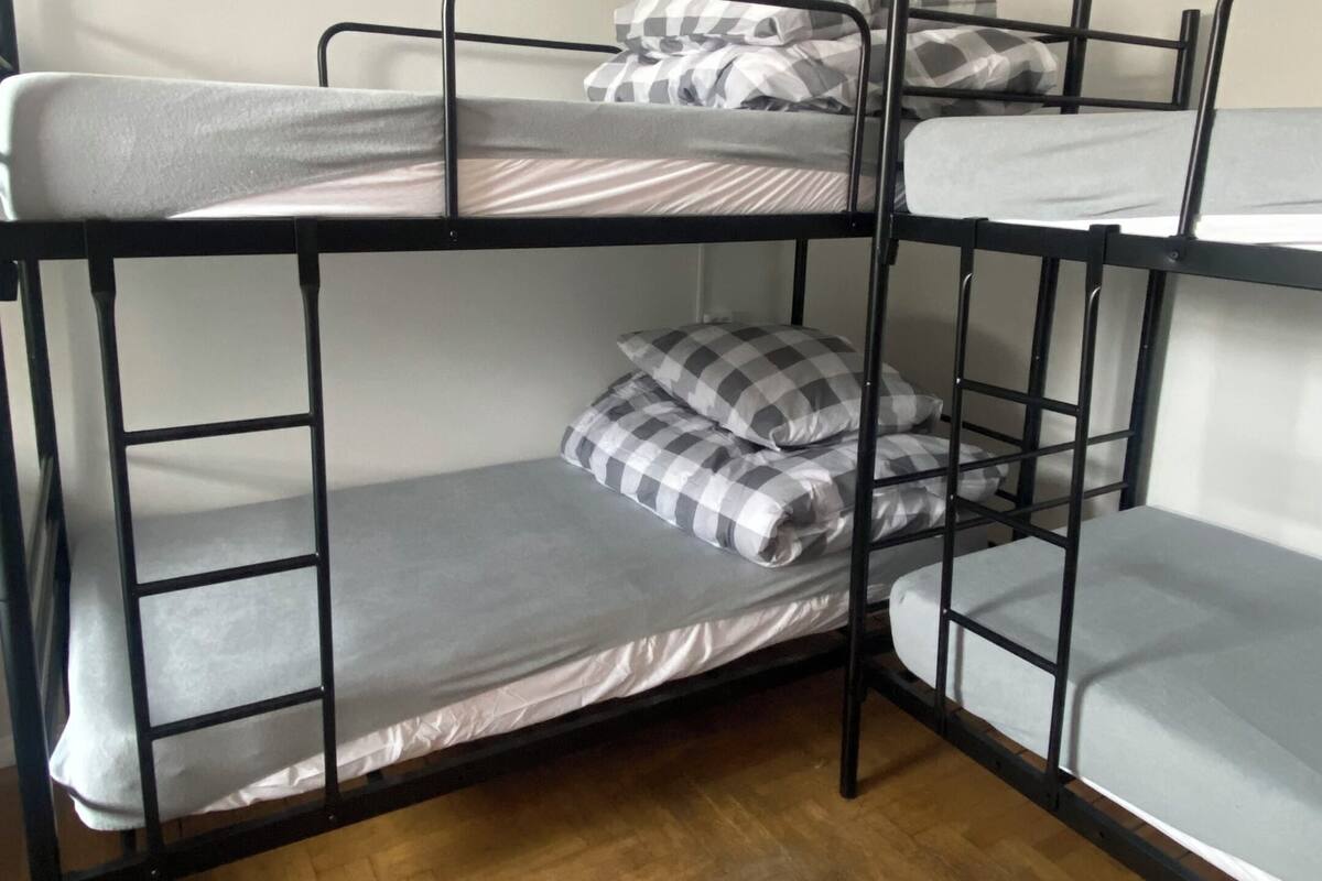 A bunk bed room with a wooden floor and white walls.