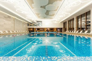 Una piscina techada, sillones reclinables de piscina