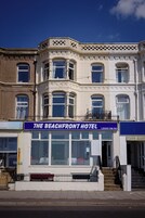 Kulmatalossa on kyltti, jossa lukee ”The Beachfront Hotel”. Siinä on suuri ikkuna, parveke ja portaat, jotka johtavat sisäänkäynnille.