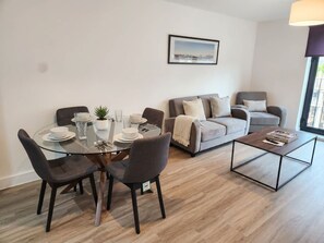 A modern living room with a dining table, two sofas, and a coffee table.