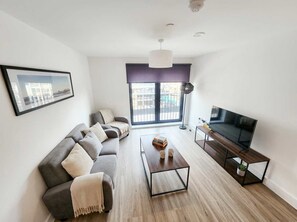 A modern living room with a sofa, coffee table, and TV.