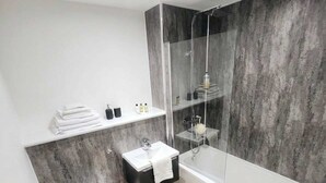 Une salle de bain moderne avec une baignoire, des toilettes et un lavabo.