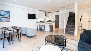 A modern apartment with a dining area, kitchen, living room, and a staircase leading to another floor. - Stylish 2BR Stay in Tonbridge Town Centre (Tonbridge)