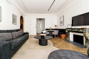 A modern living room with a sofa, a round coffee table, and a fireplace.