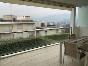 A balcony with a view of a cityscape and mountains. - Sandi Luxury Apartment (Lugano)