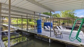 A covered outdoor pool area with lounge chairs, a blue barrel, and a green hose. - 3 BR/2 BA/Sleeps 10/Fenced Yard/Quiet Cove (Sunrise Beach)