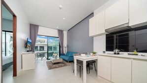 A modern apartment with a kitchen, dining area, and living room. - Naiharan Apartment UTN D604 near Beach (Rawai)