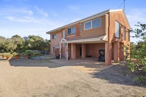 Two-story home with a flat roof, brick and stucco exterior, and a covered driveway.
