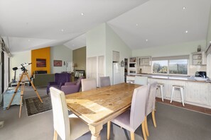 Relax in this spacious living area with a large dining table, sofa, and comfortable seating.