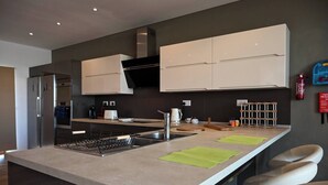 Una cocina moderna con una isla central, electrodomésticos de acero inoxidable y un horno empotrado.