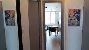 A hallway leading to a dining area with a table and chairs. - Superb T1 of 28 M2 (CAEN)