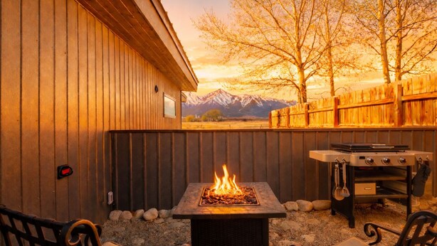 An outdoor patio with a fire feature, a grill, and a view of mountains. - Modern mountain bungalow with private patio + epic Mt. Princeton views (Buena Vista)