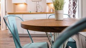 A modern kitchen with white cabinets, a wooden countertop, and a potted plant on the table. - In town with a view, private duplex. (Bryson City)