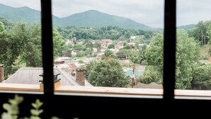 A view through a window of a town with houses, trees, and mountains in the background. - In town with a view, private duplex. (Bryson City)