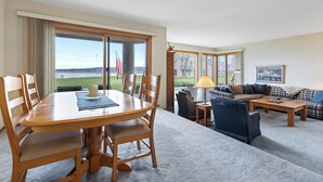 Un salon spacieux avec une grande table à manger, des sièges confortables et une vue sur un terrain de golf.