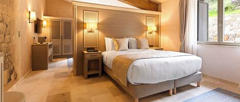 A bedroom with a large bed, bedside tables, a wardrobe, and a window with curtains.