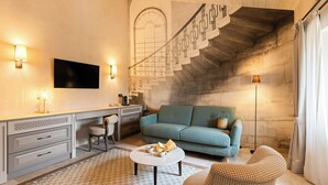 A modern living room with a sofa, a coffee table, and a TV mounted on the wall. - Le Prieuré - Château La Martinette (Le Thoronet)