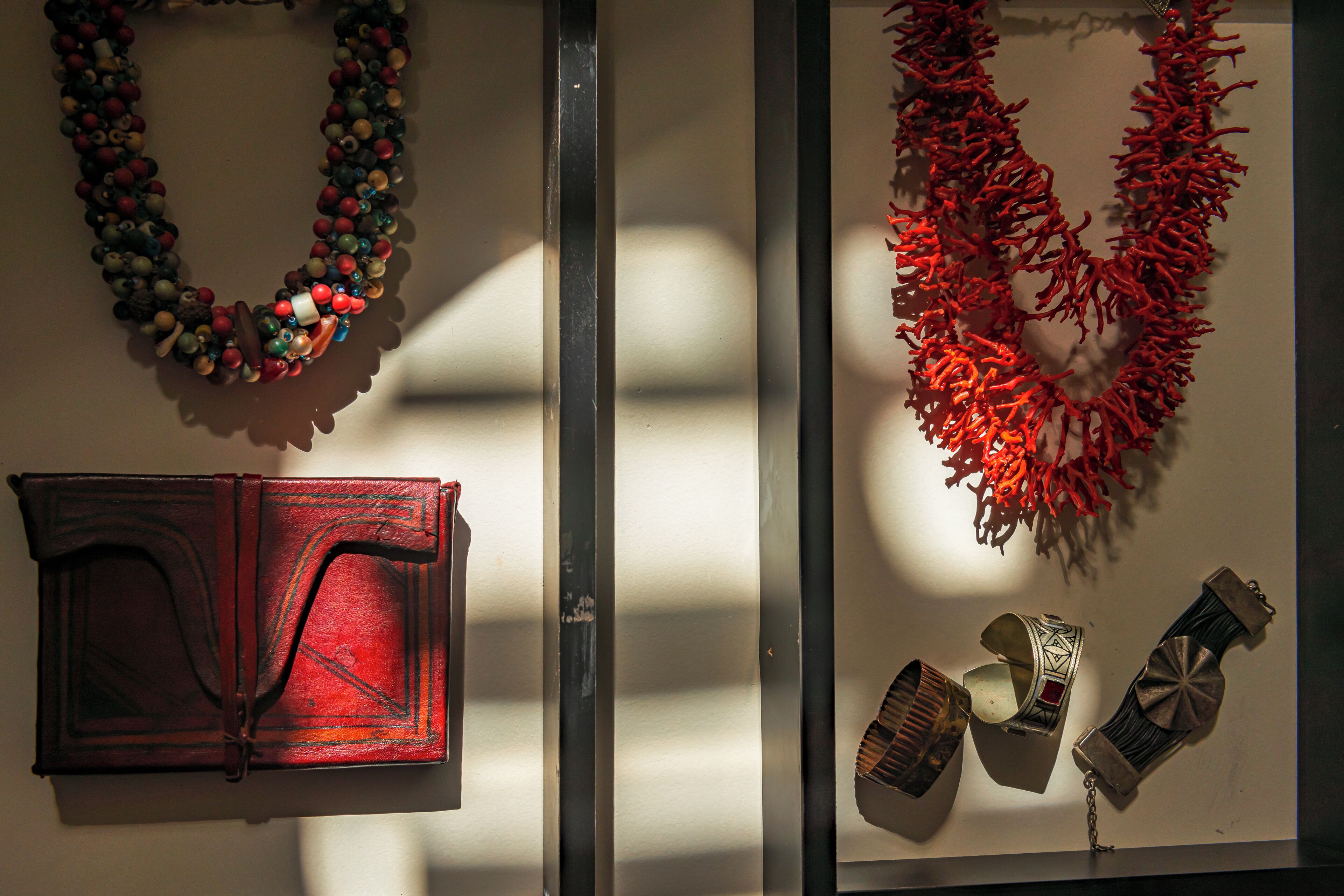 A display of various items including a red book, a necklace, and a pair of shoes.