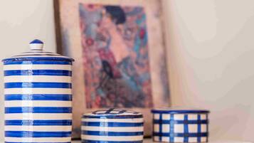 Three ceramic containers with blue and white stripes on a shelf.