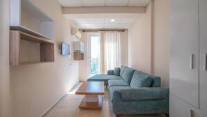 Een moderne woonkamer met een grijze bank, een houten salontafel en ingebouwde kasten.