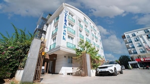 Een modern hotel met een gebogen gevel, een opvallende ingang en een hekwerk oprit.