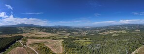 A panoramic view of a valley with rolling hills, a river, and a mountain in the distance. - Agriturismo Le Case (Castiglione d'Orcia)