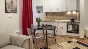 A modern apartment with a dining area, kitchenette, and a living room with a sofa. - Pet'inn II, Pet'inn II by Ruby Red House (Sofia)
