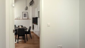 A hotel room with a bed, a dining area, and a kitchen in the background.