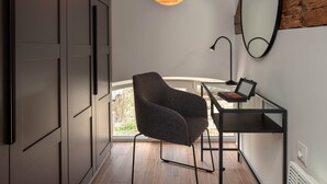 A modern room with a desk, chair, and a large mirror.