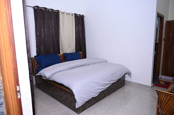 A bedroom with a bed, curtains, and a wooden headboard. - Morning Breeze Homestay Kanatal (Tehri Range)
