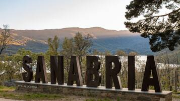 A large metal sign with the word "SANABRIA" in capital letters, mounted on a stone base with a hashtag "#VILLALUCERNA" below it.