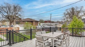 A deck with a table and chairs, surrounded by a black railing. - Walk to Shops & Eats: Home w/ Deck in Minneapolis (Minneapolis)