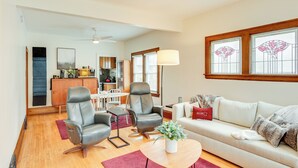 A modern living room with a sofa, two armchairs, a coffee table, and a dining area in the background. - Walk to Shops & Eats: Home w/ Deck in Minneapolis (Minneapolis)