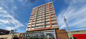 A tall, modern building with a distinctive curved design element at the top. - COARM0104 - Smart Convenções (Salvador)