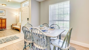 A dining area with a wooden table, metal chairs, and a window with blinds. - 6 Mi to Navarre Beach: Dog-friendly Home w/ Yard (Navarre)