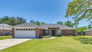 A two-story house with a garage, a front lawn, and a brick exterior. - 6 Mi to Navarre Beach: Dog-friendly Home w/ Yard (Navarre)