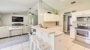 A modern kitchen with white cabinetry, a central island with bar stools, a built-in microwave, and a large oven. - 6 Mi to Navarre Beach: Dog-friendly Home w/ Yard (Navarre)