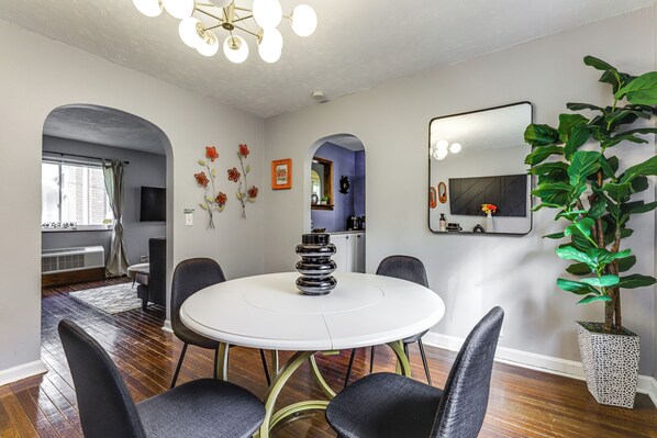 A dining area with a round table, chairs, a decorative vase, and a large mirror on the wall. - 1 Mi to University of Cincinnati: Avondale Gem! (Cincinnati)