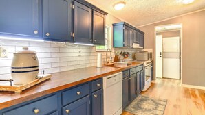 A kitchen with blue cabinets, a dishwasher, a microwave, and a stove. - Private Dock: Pet-friendly Home on Lake Sinclair (Milledgeville)