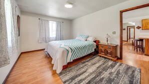Un dormitorio con cama, mesita de noche, cómoda y espejo.