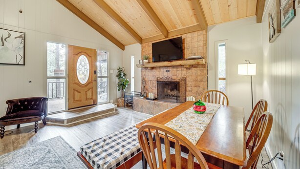 A spacious living room with a wooden ceiling, a fireplace, a dining table, and a comfortable seating area. - Near Fossil Creek & Trails: Scenic Pine Cabin! (Pine)