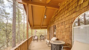 A covered outdoor area with wooden walls, a round table, two chairs, and a sofa. - Near Fossil Creek & Trails: Scenic Pine Cabin! (Pine)