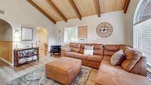 A spacious living room with a large sectional sofa, a wooden coffee table, and a decorative clock on the wall. - Near Fossil Creek & Trails: Scenic Pine Cabin! (Pine)