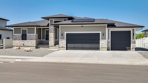 A modern two-story house with a garage, stone accents, and solar panels. - 6 Mi to Great Salt Lake: Mtn-view Retreat! (Tooele)