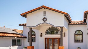 A two-story building with a tiled roof, a central archway, and a symmetrical facade. - Sunny Spanish Villa Pool Parking Privacy (Hacienda Heights)