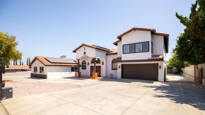 A two-story house with a garage, a driveway, and a small garden area. - Sunny Spanish Villa Pool Parking Privacy (Hacienda Heights)