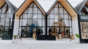 Een modern gebouw met grote glasramen en een houten gevel.