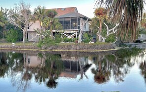Enjoy serene lakeside views from the glass-enclosed porch of this peaceful retreat.