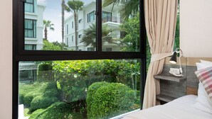 A hotel room with a large window, a bed, a bedside table, and a lamp. - Title Rawai Tropical View Apartment B209 (Rawai)