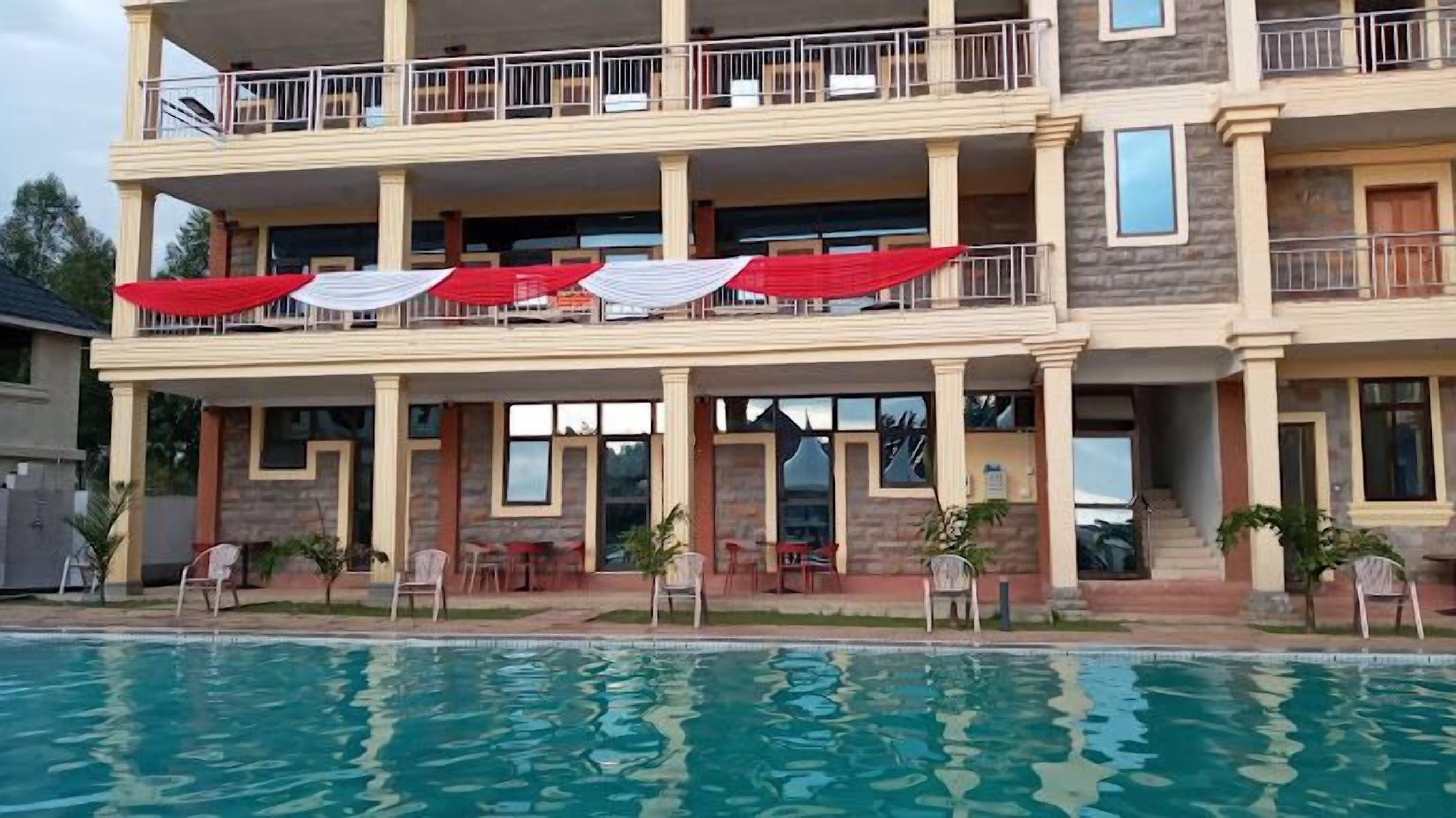 A multi-story building with a pool in the foreground.